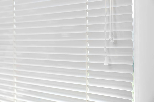 Window with closed modern horizontal blinds indoors. Space for text - Фото, изображение