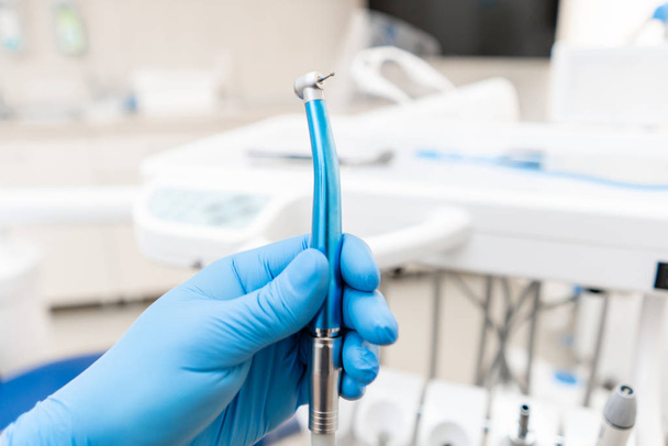 Lähikuva käsi hammaslääkäri käsine omistaa hampaiden nopea turbiini. Toimisto, jossa hammaslääkäri suorittaa tarkastuksen ja päättää. - Valokuva, kuva