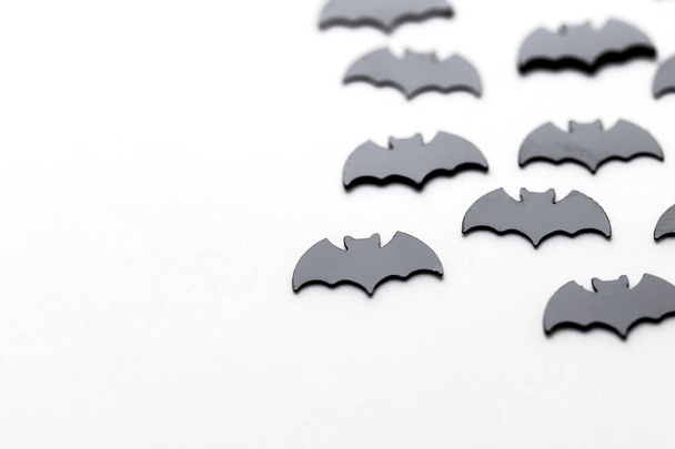Black bat shapes on a white background. Halloween background - Photo, Image