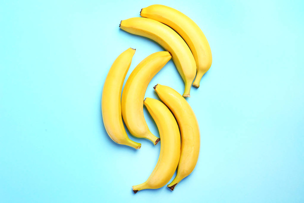 Ripe tasty bananas on blue background, flat lay - Photo, Image