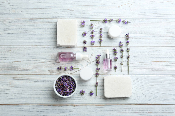 Flat lay composition of handmade soap bars with lavender flowers and ingredients on white wooden background - Фото, зображення