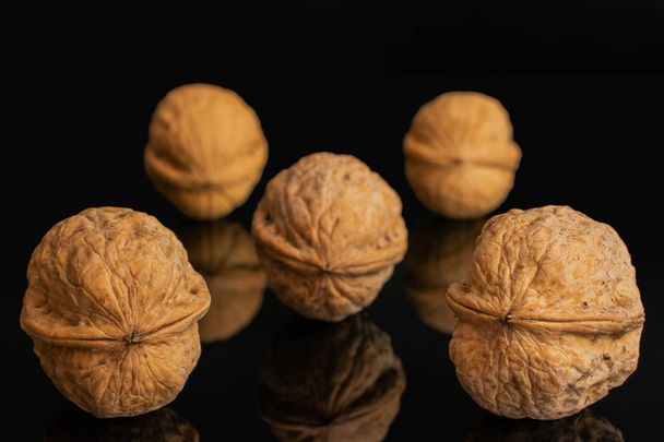 Ripe brown walnut isolated on black glass - Fotó, kép