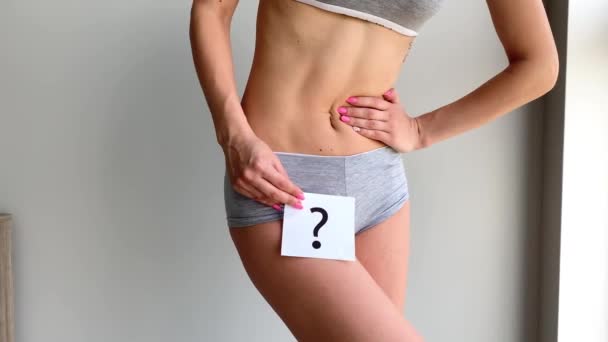 Salud. Mujer cuerpo en ropa interior con tarjeta de preguntas cerca del vientre
. - Metraje, vídeo