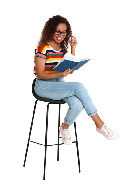Beautiful African-American woman reading book on white background - Φωτογραφία, εικόνα
