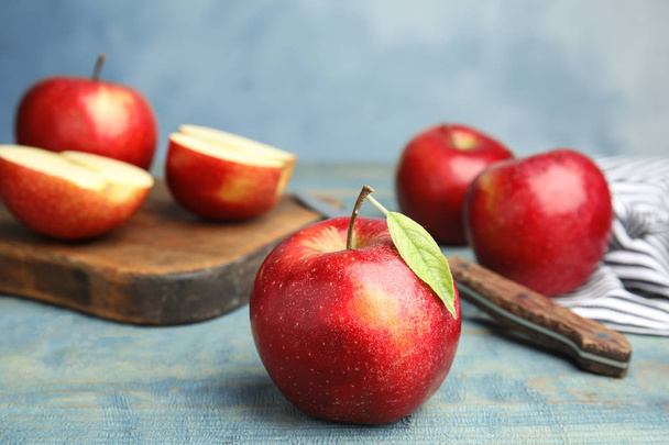 Ripe juicy red apples on wooden table against blue background. Space for text - Fotografie, Obrázek