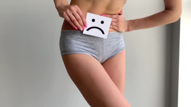 Zdraví ženy. Ženské tělo drží smutný úsměv kartu v blízkosti žaludku. - Záběry, video