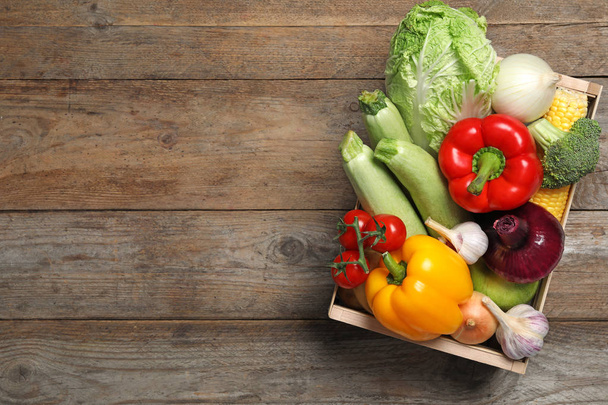 Fresh vegetables in crate on wooden background, top view. Space for text - Фото, зображення