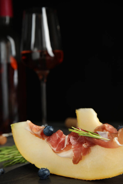 Melon with prosciutto, blueberries and rosemary on table - Valokuva, kuva