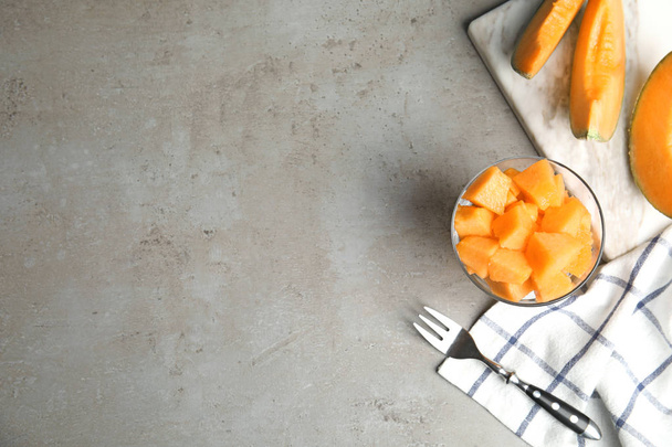Flat lay composition with ripe cantaloupe melon on grey table. Space for text - Фото, зображення