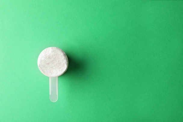Scoop of protein powder on green background, top view with space for text - Foto, Imagem