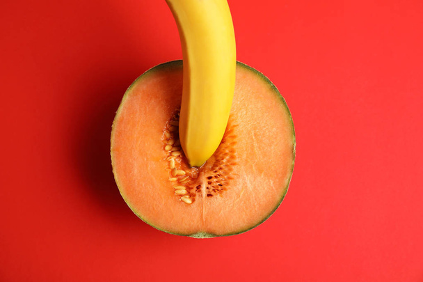 Flat lay composition with fresh banana and melon on red background. Sex concept - Photo, Image