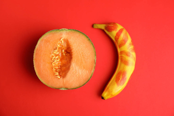 Flat lay composition with fresh banana and melon on red background. Sex concept - Foto, afbeelding
