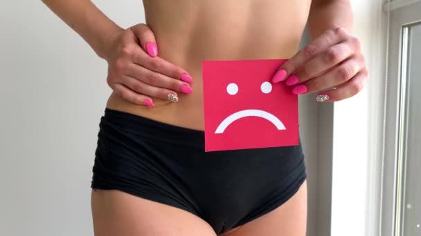 Zdraví ženy. Ženské tělo drží smutný úsměv kartu v blízkosti žaludku. - Záběry, video