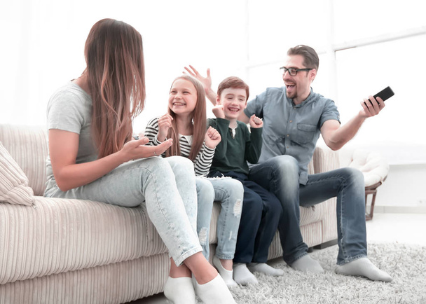happy family sitting watching TV in their home - Foto, Bild