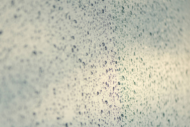 Rain drops on window glasses surface on the dark cloudy sky background - Photo, image