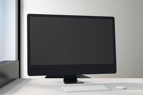 Black blank screen of black computer monitor on white table in light office. - Foto, imagen