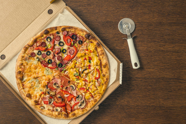 four different pieces of pizza in the open delivery box - Foto, Imagen