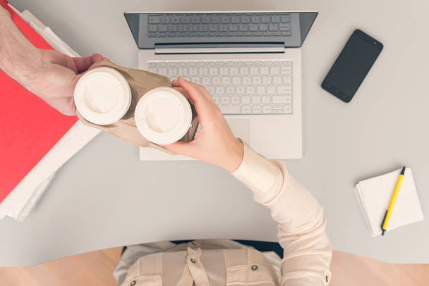 Man bringing coffee in paper cups to colleague woman - Φωτογραφία, εικόνα