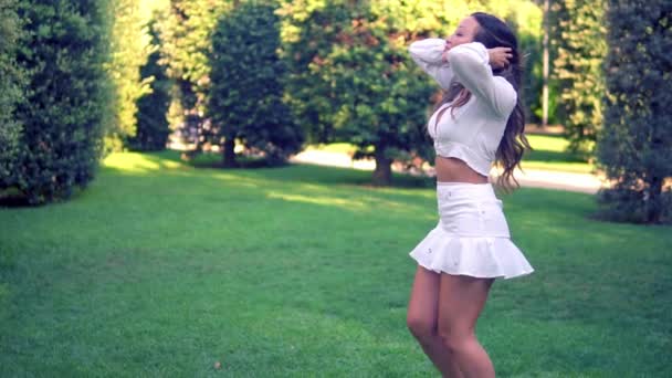 Beautiful Asian girl in white dress smiling in the park - Felvétel, videó