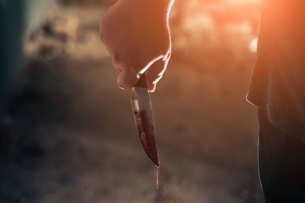 Αρσενικό δολοφόνο χέρι κρατώντας το μαχαίρι στο αίμα σε σκούρο τρομακτικό σπίτι - Φωτογραφία, εικόνα