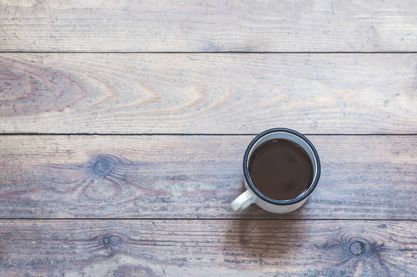 iron mug with coffee on the wooden floor. concept - Foto, afbeelding