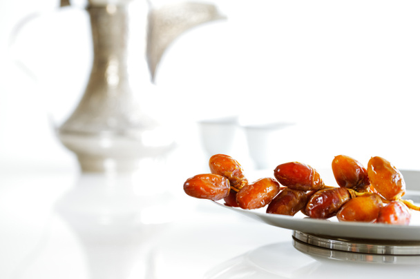 Arabic dates on a plate with Arabic coffee pot of the Bedouin - Photo, Image