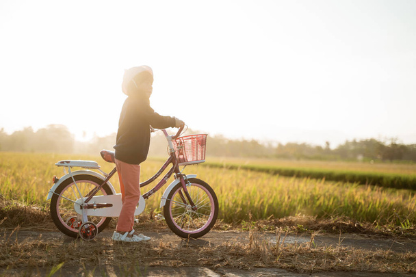 independiente asiático niño paseo su bicicleta
 - Foto, Imagen