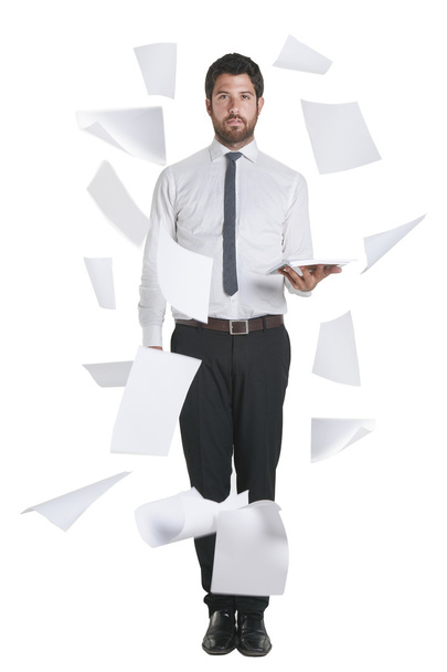 Young businessman standing with flying papers. - 写真・画像
