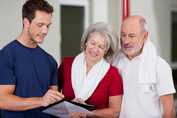 Instructor Showing Health Results On Clipboard To Senior Couple - 写真・画像
