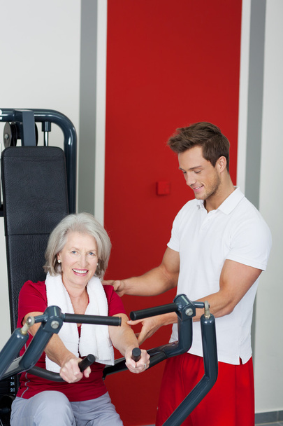 Senior Woman Being Assisted By Trainer In Using Rowing Machine - Fotoğraf, Görsel