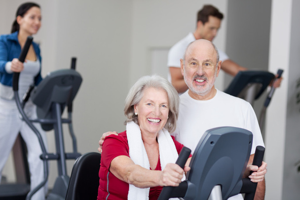 Happy Senior Couple With Using Treadmill In Background At Gym - Φωτογραφία, εικόνα