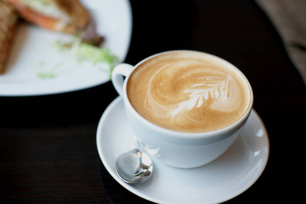 горячий кофе с молоком на столе в кафе
 - Фото, изображение