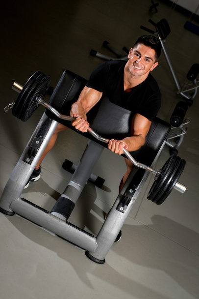 Handsome muscular man exercising in Gym - 写真・画像