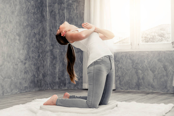 Young woman yoga on carpet at home living room.  - Photo, Image
