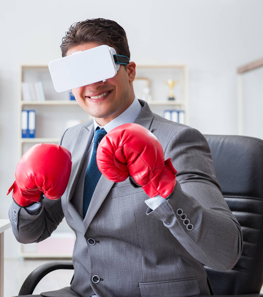 Mann boxt im Büro mit Virtual-Reality-Brille - Foto, Bild