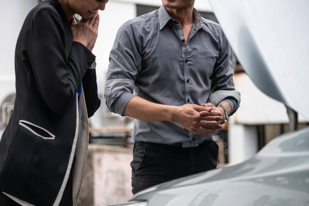男は女性が車の問題を修正するのを助ける. - 写真・画像