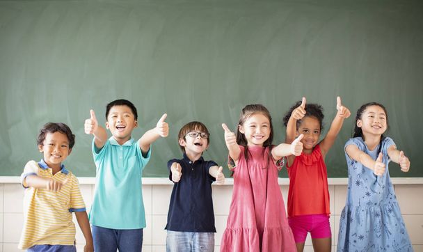 Multi-etnische groep van schoolkinderen die in de klas staan - Foto, afbeelding