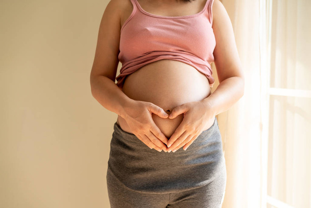 Happy pregnant woman and expecting baby at home. - Foto, Imagen