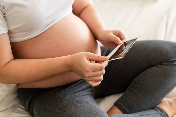 Happy pregnant woman and expecting baby at home. - Valokuva, kuva