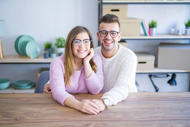 Young beautiful couple sitting on the table at home, hugging in  - Foto, immagini