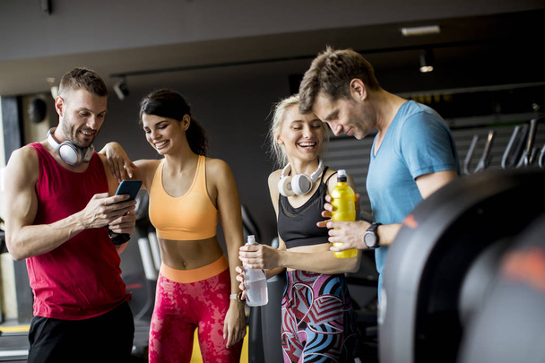 Group of sporty young people standing at the gym - Photo, Image