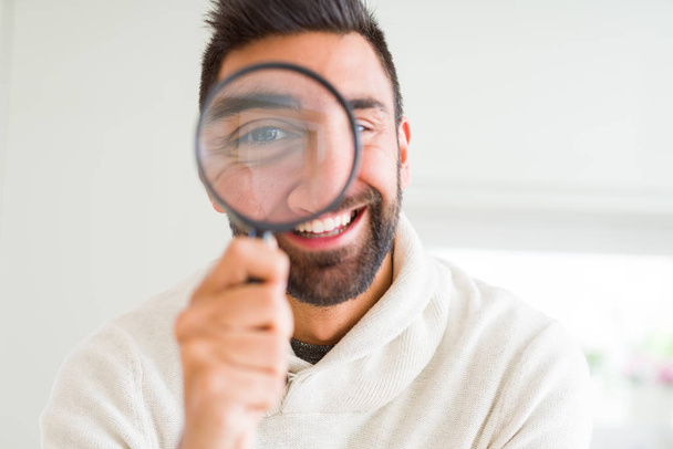 Handsome man using magnifying glass, doing funny faces - Foto, Imagem
