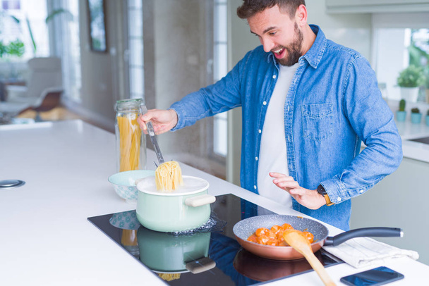 Красивий чоловік готує макарони вдома
 - Фото, зображення