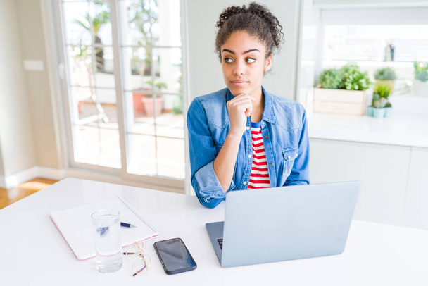 Genç afro-amerikan öğrenci kadın bilgisayar dizüstü bilgisayar kullanarak ciddi yüz soru hakkında düşünme, çok karışık bir fikir - Fotoğraf, Görsel