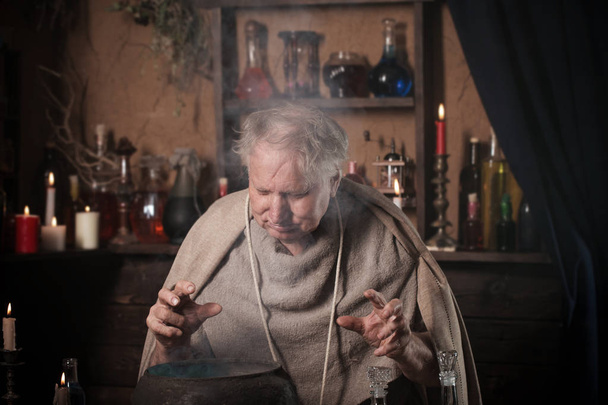 elderly alchemist monk brews  magic potion - Fotografie, Obrázek