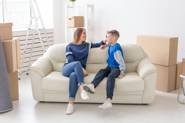 Elégedett boldog kaukázusi anya és fia boldogan kommunikálni megvitatása Deisgn az új lakás alatt housewarming fél. - Fotó, kép