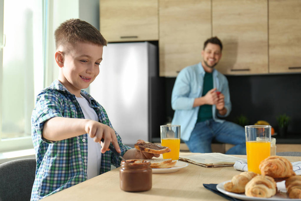 Dad and son having breakfast together in kitchen - Photo, Image