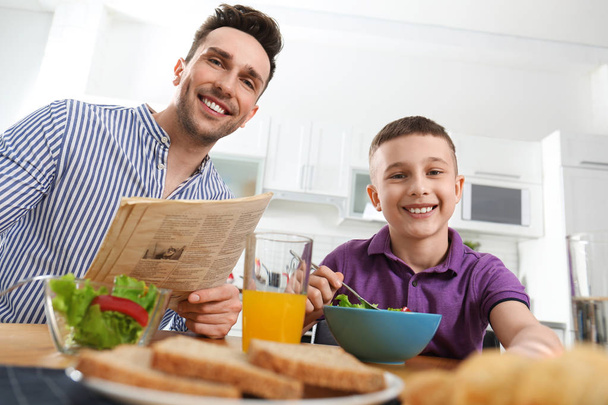 Dad and son having breakfast together in kitchen - Valokuva, kuva