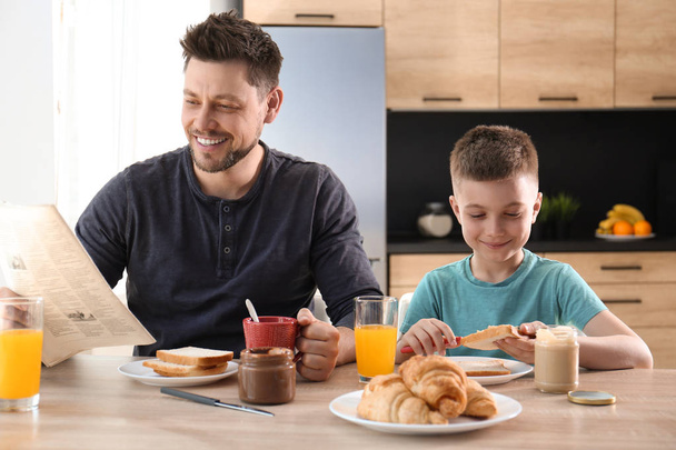 Baba ve oğul mutfakta birlikte kahvaltı yapıyor - Fotoğraf, Görsel