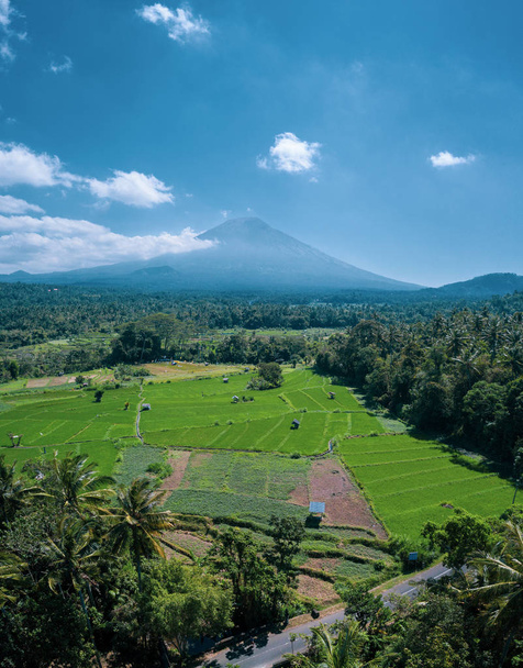 Drohnenaufnahme des Vulkans und schöne Felder Landschaft während sonnigem Sommertag in Bali, Indonesien - Foto, Bild